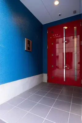 a room with a red door and a blue wall at Asakusa Good Place Unmanned Hotel in Tokyo