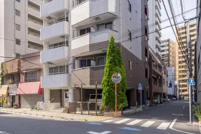 a stop sign in front of a tall building at Asakusa Good Place Unmanned Hotel in Tokyo