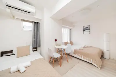 a white bedroom with a bed and a table at Shinjuku luxury high-rise apart ment in Tokyo