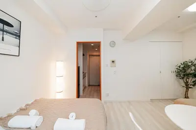 a white room with a bed and a hallway at Shinjuku luxury high-rise apart ment in Tokyo