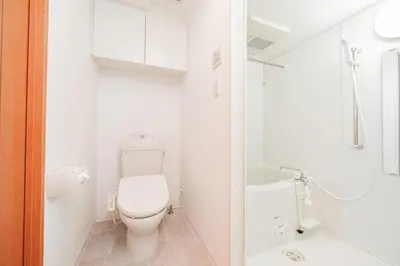 a white bathroom with a toilet and a sink at Shinjuku luxury high-rise apart ment in Tokyo