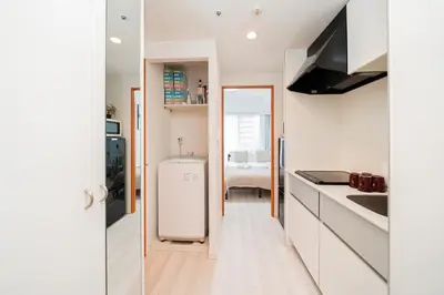 a kitchen with white cabinets and a white refrigerator at Shinjuku luxury high-rise apart ment in Tokyo