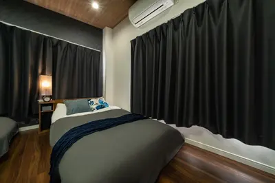 a bedroom with a bed and a window with black curtains at 99, Higashi-tateishi A 2nd and 3rd floor apartment, \u6771\u7acb\u77f3A 2F,3F in Tokyo