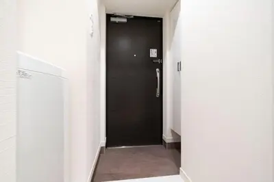 a hallway with a black door in a room at \u30eb\u30af\u30ec\u897f\u65b0\u5bbf in Tokyo