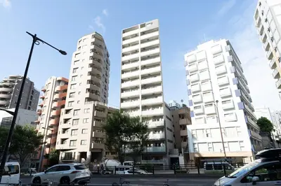 two tall white buildings in a city with cars at \u30eb\u30af\u30ec\u897f\u65b0\u5bbf in Tokyo