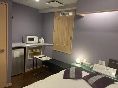 a room with a bed and a kitchen with a microwave at \u30db\u30c6\u30eb\u30b7\u30a7\u30cc\u30fcAdult Only in Tokyo