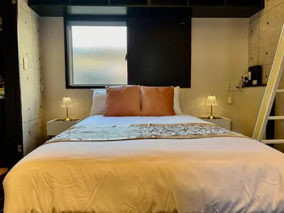 a bedroom with a large bed with a window at CoreHOTEL in Tokyo