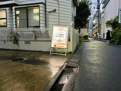 a sign sitting on the side of a street at CoreHOTEL in Tokyo