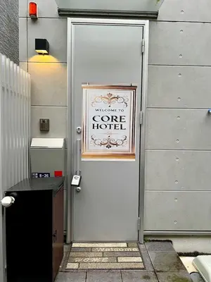 a white door with a sign on it at CoreHOTEL in Tokyo