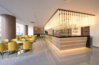 a cafeteria with yellow chairs and tables in a building at COCOYO Hotel \u5927\u585a in Tokyo