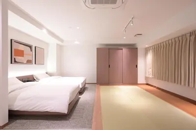 a bedroom with two beds and a window at COCOYO Hotel \u5927\u585a in Tokyo