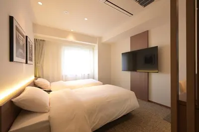 a hotel room with two beds and a television at COCOYO Hotel \u5927\u585a in Tokyo