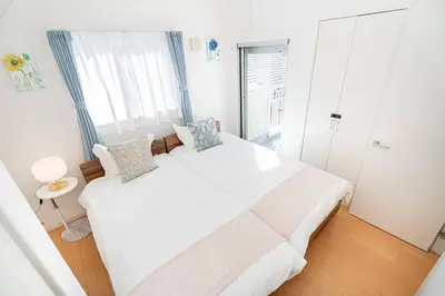 a white bedroom with a large white bed with pillows at new open \u8cb8\u5207\u4e00\u8ed2\u5bb6 \u65b0\u5927\u4e45\u4fdd\u99c5\u5f92\u6b6913\u5206 \u5927\u4e45\u4fdd\u99c5\u5f92\u6b697\u5206 \u897f\u65b0\u5bbf\u99c5\u5f92\u6b699\u5206 in Tokyo