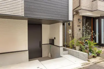 a front door of a house with plants at \u677e\u6c5f7\u4e01\u76ee\u6238\u5efa in Tokyo