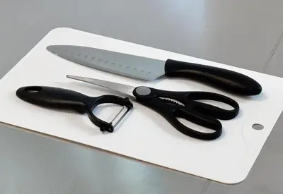 a pair of scissors and a knife on a cutting board at \u677e\u6c5f7\u4e01\u76ee\u6238\u5efa in Tokyo