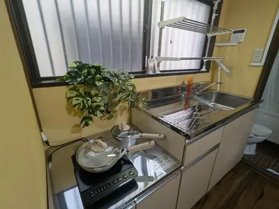 a small kitchen with a stove and a sink at Matsuri House 20min to Ueno in Tokyo
