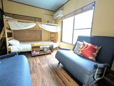 a living room with a bunk bed and a chair at Matsuri House 20min to Ueno in Tokyo