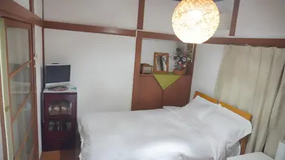 a bedroom with a white bed and a lamp at Uhome Tsubame Apartment in Tokyo