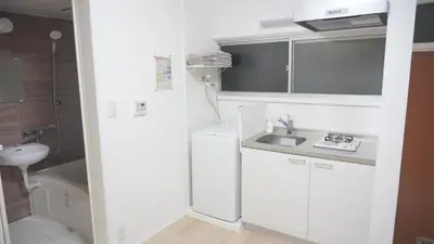 a small white kitchen with a sink and a toilet at Uhome Tsubame Apartment in Tokyo