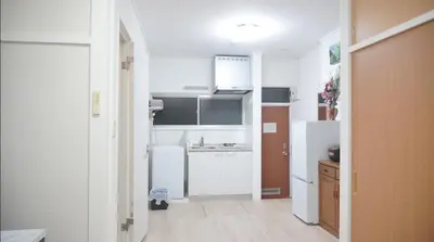 a small kitchen with white appliances in a room at Uhome Tsubame Apartment in Tokyo