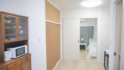 a room with a bedroom with a microwave and a tv at Uhome Tsubame Apartment in Tokyo