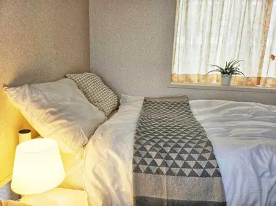 a bedroom with a bed and a window with a plant at Open #\uc2e0\uc8fc\ucfe05\ubd84#\uc2dc\ubd80\uc57c10\ubd84#\uc624\ucfe0\ubcf4\uc5ed3\ubd84#\ub2e4\ub2e4\ubbf8\uc544\ud30c\ud2b8#\uce68\uc2e43\uac1c#\ube54\ud504\ub85c\uc81d\ud130#84m2#\ubca0\uc2a4\ud2b8\uc2ac\ub9bd\ub9e4\ud2b8\ub9ac\uc2a4 in Tokyo