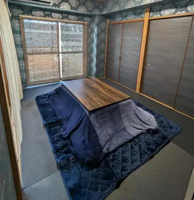 a bedroom with a bed and a wooden table at 20min to Haneda airport Vista Ikegami in Tokyo