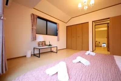 a bedroom with a large bed with two towels on it at \u6c60\u888b\u7535\u8f663\u5206\u65b0\u5bbf11\u5206\u6da9\u8c3718\u5206\u94f6\u5ea724\u5206\u99c5\u307e\u3067\u5f92\u6b695\u5206\u8cb8\u5207\u6700\u59278\u4eba in Tokyo