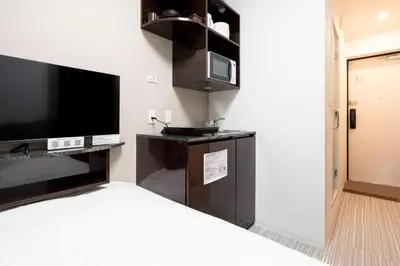 a hotel room with a bed and a flat screen tv at FK Place\u795e\u697d\u5742 in Tokyo