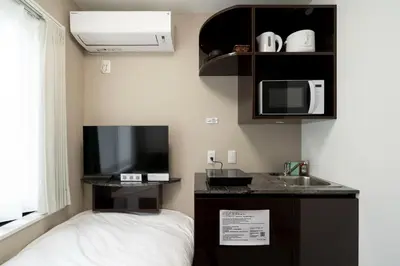 a room with a bed and a sink and a tv at FK Place\u795e\u697d\u5742 in Tokyo
