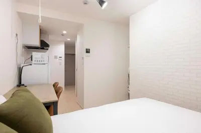 a kitchen with a couch and a white brick wall at \u30cf\u30fc\u30d0\u30fc\u30ba\u30ec\u30b8\u30c7\u30f3\u30b9\u516b\u5e83 in Tokyo