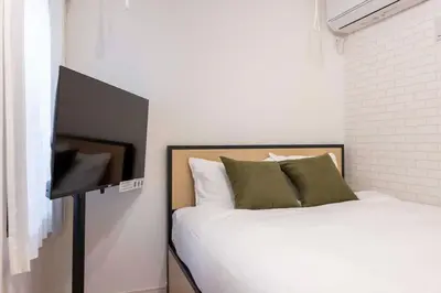 a bedroom with a bed and a flat screen tv at \u30cf\u30fc\u30d0\u30fc\u30ba\u30ec\u30b8\u30c7\u30f3\u30b9\u516b\u5e83 in Tokyo