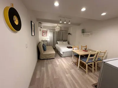 a room with a bed and a table and a bed and a kitchen at 5minutes from Shinjuku Shin-Okubo Station-k101 in Tokyo