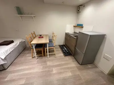 a small kitchen with a table and a refrigerator at 5minutes from Shinjuku Shin-Okubo Station-k101 in Tokyo