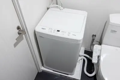 a washing machine in a bathroom next to a toilet at APRO Stay \u54c1\u5ddd in Tokyo