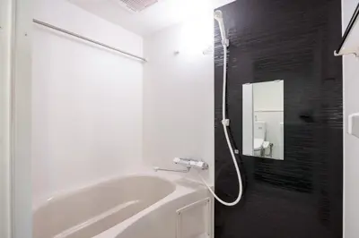 a white bath tub in a bathroom with a mirror at APRO Stay \u54c1\u5ddd in Tokyo
