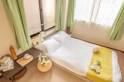 a bedroom with a large window with green curtains at Lucky House\u65b0\u5bbf21 in Tokyo