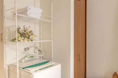 a laundry room with a washing machine and towels at Lucky House\u65b0\u5bbf21 in Tokyo