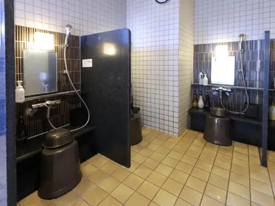 a public bathroom with three urinals in a room at Dormy Inn Ueno Okachimachi in Tokyo