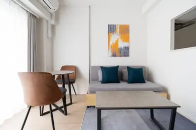 a living room with two beds and a table at \u30a2\u30fc\u30d0\u30f3\u30d1\u30fc\u30af\u672c\u6240\u543e\u59bb\u6a4b in Tokyo