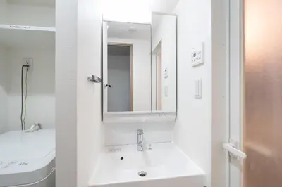 a white bathroom with a sink and a mirror at \u30a2\u30fc\u30d0\u30f3\u30d1\u30fc\u30af\u672c\u6240\u543e\u59bb\u6a4b in Tokyo