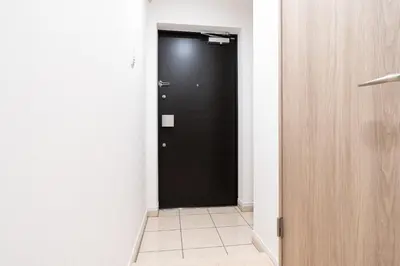 a hallway with a black door and a tile floor at \u30a2\u30fc\u30d0\u30f3\u30d1\u30fc\u30af\u672c\u6240\u543e\u59bb\u6a4b in Tokyo