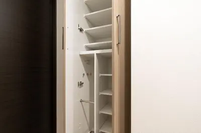 a closet with white shelves and a door at \u30a2\u30fc\u30d0\u30f3\u30d1\u30fc\u30af\u672c\u6240\u543e\u59bb\u6a4b in Tokyo