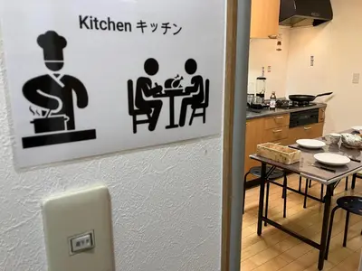 a kitchen with a table and a sign on the wall at Entire Hotel Beside Asakusa, Ueno, Akihabara and Tokyo Skytree tower between 3 Train Stations and Contains 3 Bedrooms, 2 Bathrooms and 2 toilets for 14 guests in Tokyo