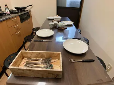 a table with plates and silverware in a wooden box at Entire Hotel Beside Asakusa, Ueno, Akihabara and Tokyo Skytree tower between 3 Train Stations and Contains 3 Bedrooms, 2 Bathrooms and 2 toilets for 14 guests in Tokyo