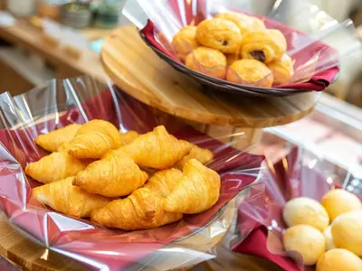 a plate of pastries on a table with a bowl of donuts at Super Hotel Ikebukuro-Eki Kitaguchi in Tokyo