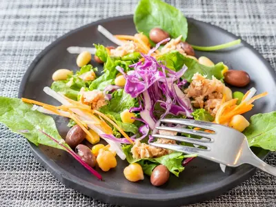 a plate of food with a salad with a fork at Super Hotel Ikebukuro-Eki Kitaguchi in Tokyo