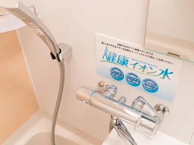 a bathroom with a shower and a sign on the wall at Super Hotel Ikebukuro-Eki Kitaguchi in Tokyo