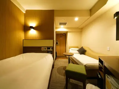 a hotel room with two beds and a table at Super Hotel Ikebukuro-Eki Kitaguchi in Tokyo