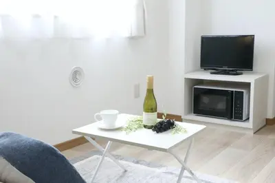 a living room with a table with a bottle of wine at Voere\u5927\u4e95\u753a 302 in Tokyo